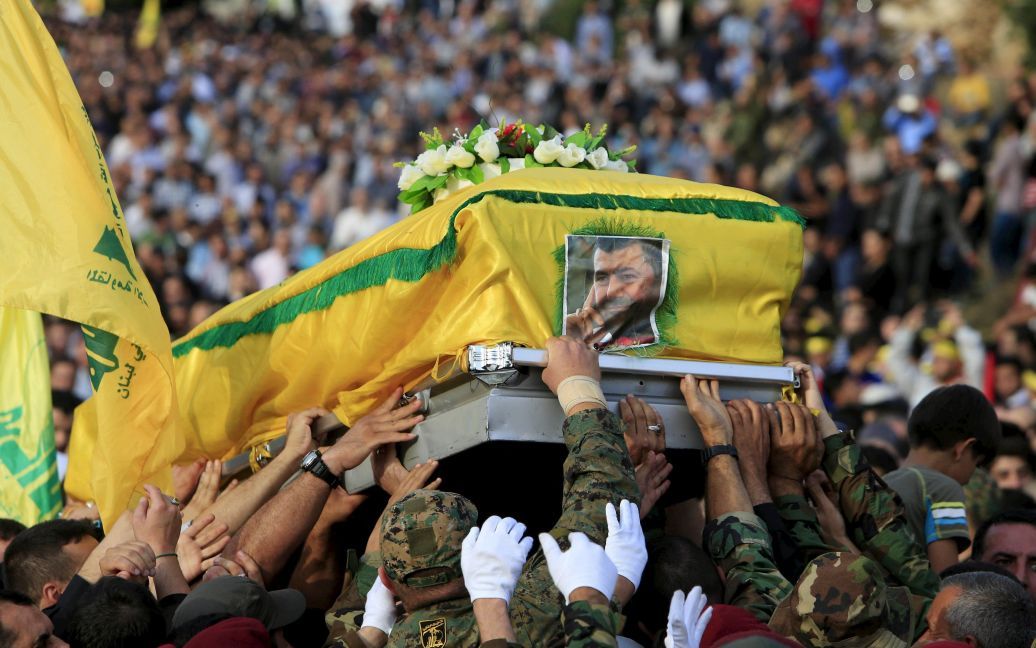Участники ливанского исламистского движения "Хезболла" несут гроб с одним из лучших своих командиров Хасаном аль-Хаджем, который был убит во время боев на стороне режима Башара Асада в сирийской провинции Идлиб. "Хезболла" воюет на стороне Асада против сирийской оппозиции и боевиков "Исламского государства". / © Reuters