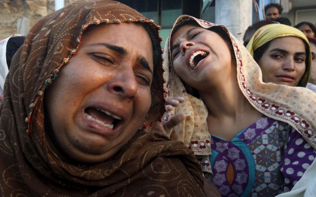 Родственники скорбят, увидев тело жертвы, которое извлекли из-под завалов оползня в районе Гулистан-я-Джаухар в Карачи, Пакистан. По крайней мере 13 человек, в том числе семь детей, погибли из-за оползня. / © Reuters