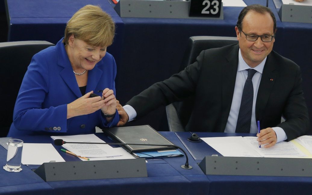 Президент Франции Франсуа Олланд касается руки канцлера Германии Ангелы Меркель, когда к ней обращаются во время дебатов в Европейском парламенте. Меркель и Олланд обратились к Европарламенту, надеясь укрепить сплоченность ЕС перед лицом новых угроз, связанных с миграцией и экономикой. / © Reuters