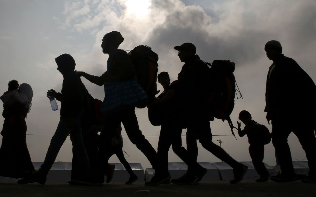 Мигранты идут на автобус до Никкельсдорфа, Австрия. Многие из почти 400 000 мигрантов, прибывших в этом году из Греции, позже добрались до Германии через территорию Австрии. / © Reuters
