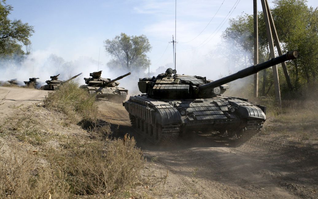 Боевики "ЛНР" едут на танках подальше от линии фронта в Донбассе. 3 октября в зоне АТО начался процесс отвода танков и вооружения калибром до 100 мм от линии соприкосновения. / © Reuters