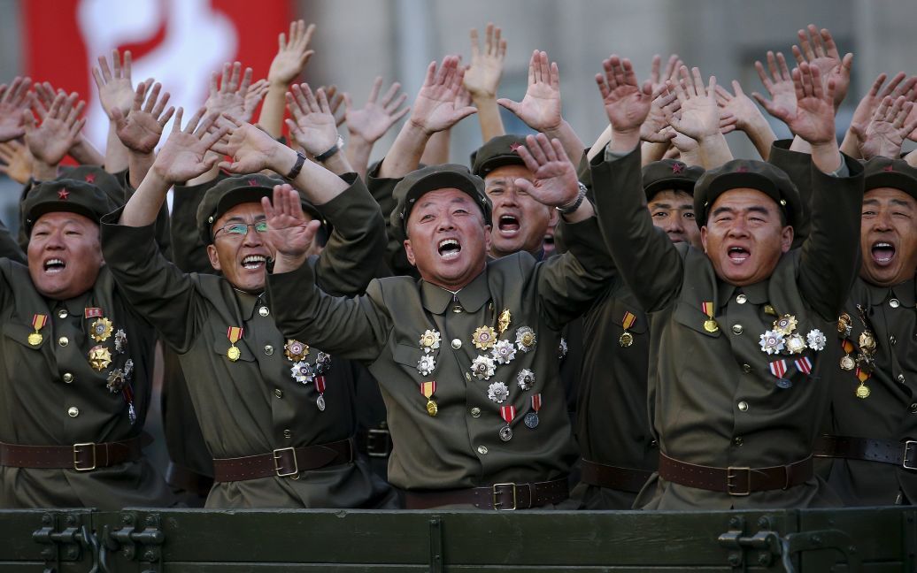 Ветераны северокорейской армии реагируют на стенд с лидером КНДР Ким Чен Ыном во время парада в честь 70-летия Трудовой партии Кореи. Северная Корея отметила праздник масштабным военным парадом, а Ким Чен Ын заявил, что его страна готова к любой войне с США. / © Reuters