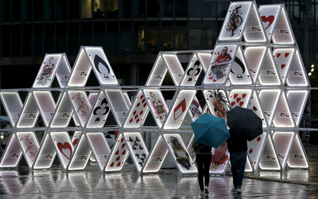 Люди смотрят на световую инсталляцию под названием "Карточный домик" во время технической проверки для Фестиваля Света в Берлине. / © Reuters
