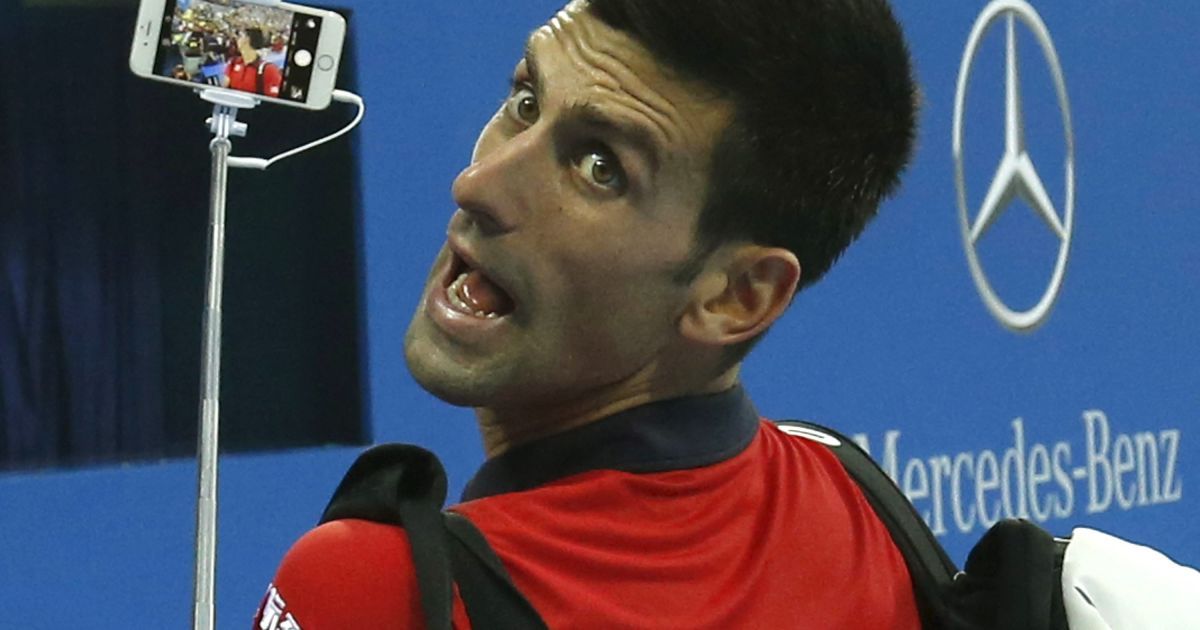 Теннисист Новак Джокович из Сербии делает Селфи с мобильного телефона фаната после победы над Симоне Болелли из Италии на турнире China Open в Пекине, Китай.