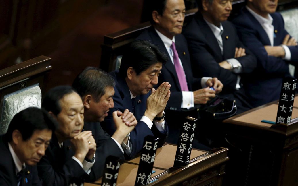 Инициатор изменений Конституции премьер Синдзо Абэ (в центре) следит за голосованием депутатов. / © Reuters