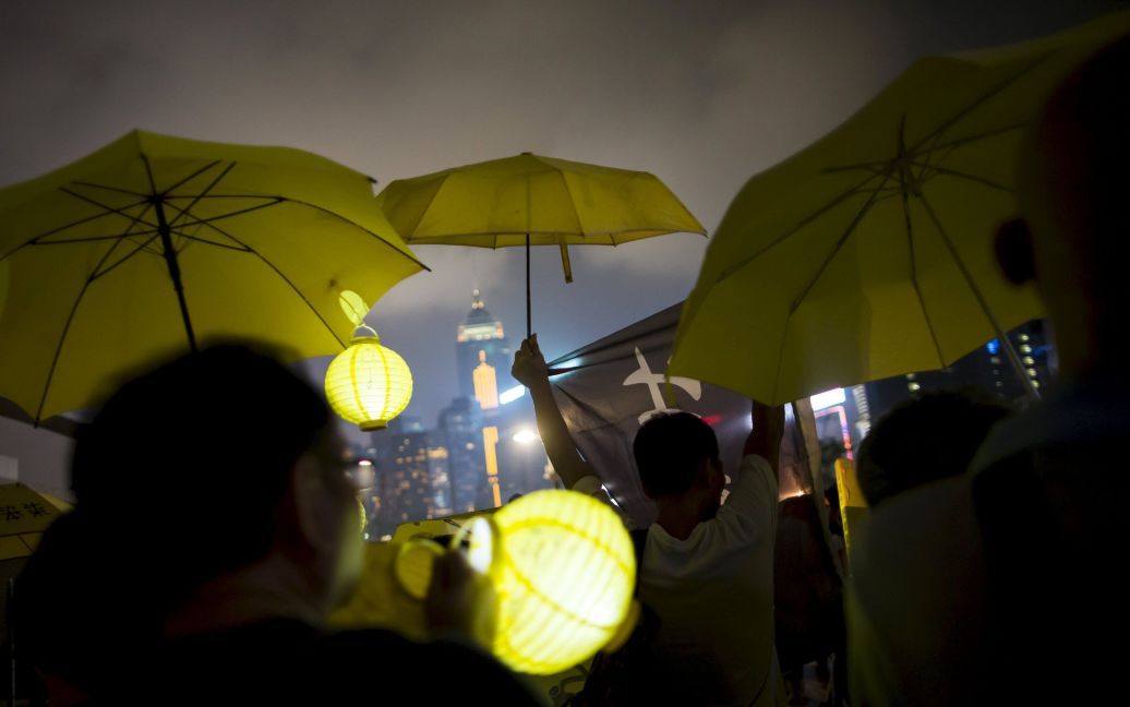 Про-демократические протестующие держат желтые зонтики, символ движения Оккупай в Гонконге. 26 сентября они промаршировали в штаб-квартиру правительства за два дня до первой годовщины &laquo;Революции зонтиков" - акции гражданского неповиновения в Гонконге против авторитарной системы выборов. / © Reuters