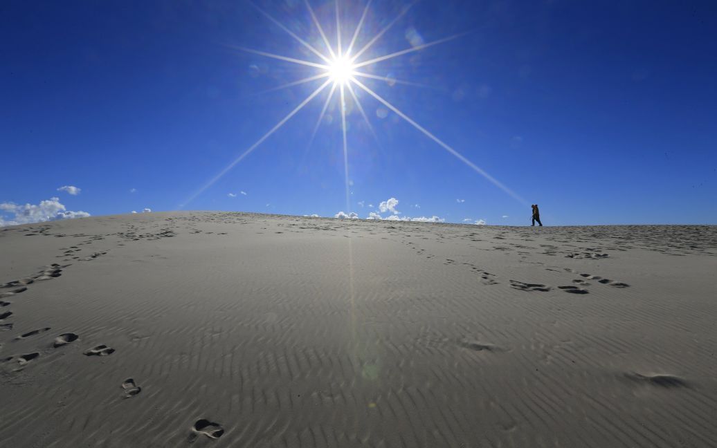 Турист ходит по вершине дюны в Словинском национальном парке в Польше. Эти дюны являются самыми высокими песчаными дюнами в регионе, их высота достигает 42 метров. / © Reuters