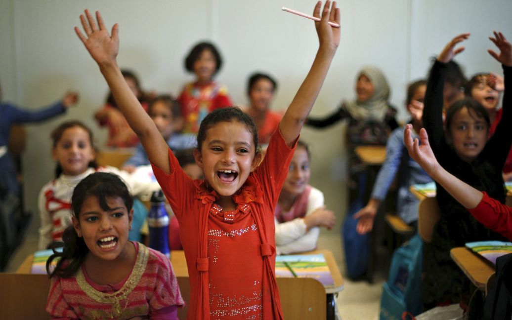 Сирийские беженцы на занятиях в школе ЮНИСЕФ во время визита министра экономики Германии Зигмар Габриэль в лагерь беженцев в иорданском городе Мафрак, что недалеко от границы с Сирией. / © Reuters