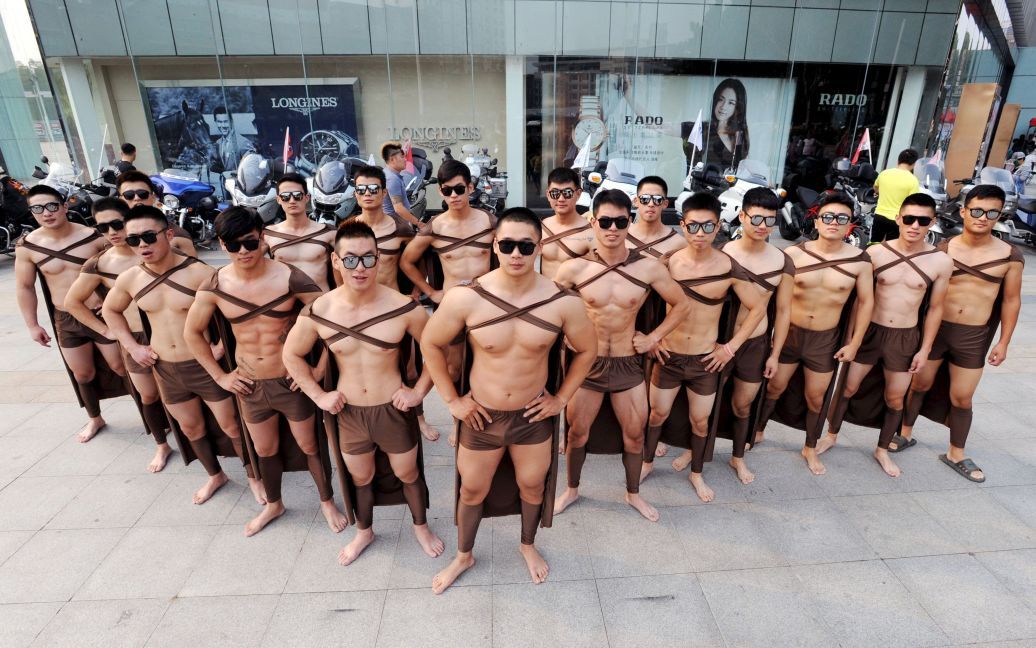 Фитнес-инструкторы и ученики, одетые в спартанских воинов, стоят во время празднования первой годовщины компании Juicedaily, которая производит сок. / © Reuters