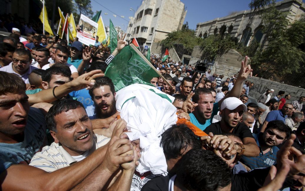 Палестинцы несут тело 19-летней студентки Хадиль аль-Хашламун во время ее похорон в городе Хеврон. Накануне израильские военные расстреляли ее, обвинив в попытке ударить ножом солдата. Родственники девушки со своей стороны заявляют, что она была казнена. / © Reuters