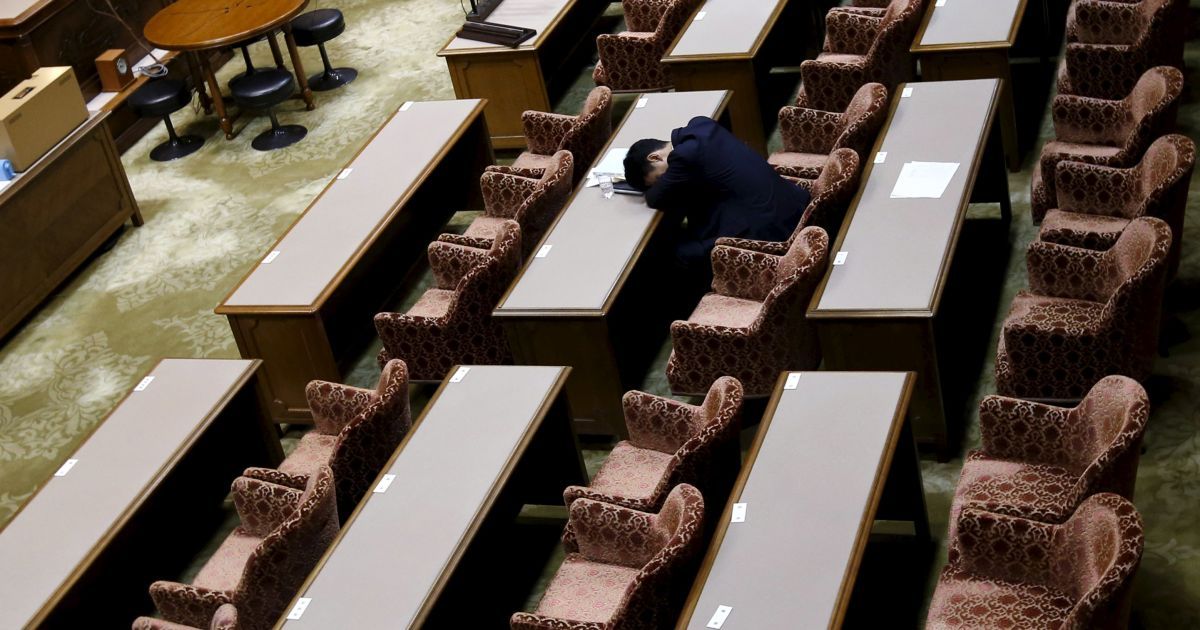 Депутат японского парламента ждет начала специальной сессии комитета верхней палаты для окончательного обсуждения закона, связанных с безопасностью. Депутаты могут разрешить своим войскам воевать за границей впервые со времен Второй мировой войны, несмотря на многочисленные протесты рядовых избирателей. / © Reuters