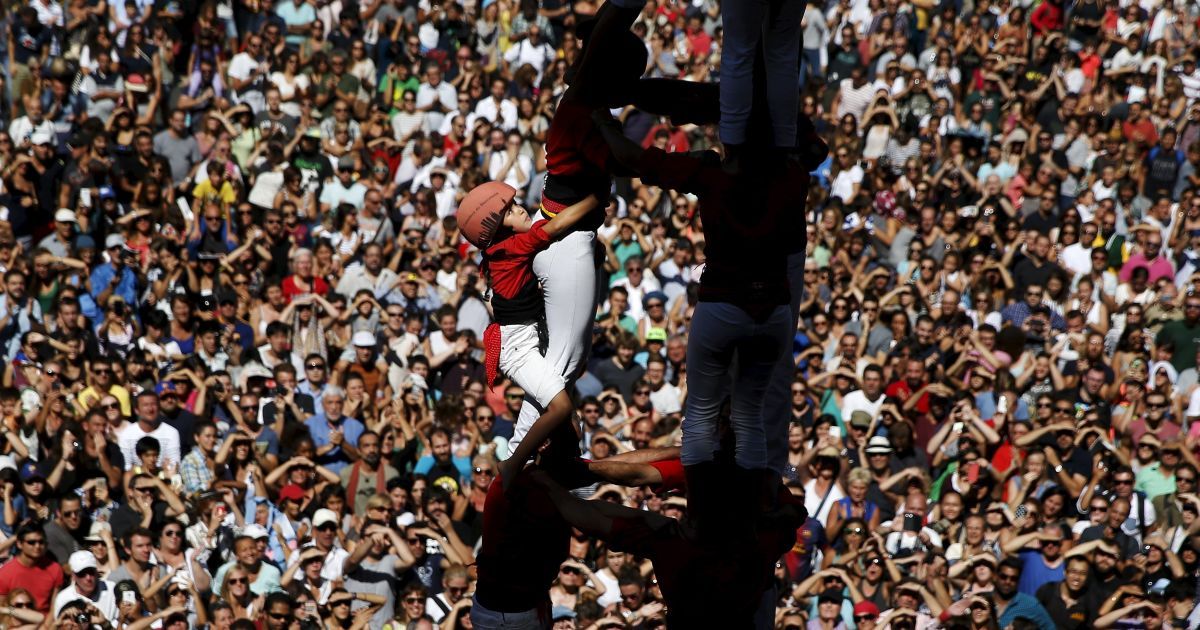 Члены команды &laquo;Castellers Barcelona" строят башню из людей во время фестиваля святой покровительницы Барселоны "Богоматерь Милосердия" на площади Сан-Жауме в Барселоне. Традиция строить такие башни длится в Каталонии с 18-го века. / © Reuters
