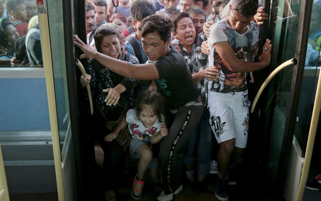 Беженцы толкают друг друга, чтобы попасть в автобус. В Грецию они прибыли морским судном в поисках лучшей жизни, ведь в Сирии сейчас идет война / © Reuters