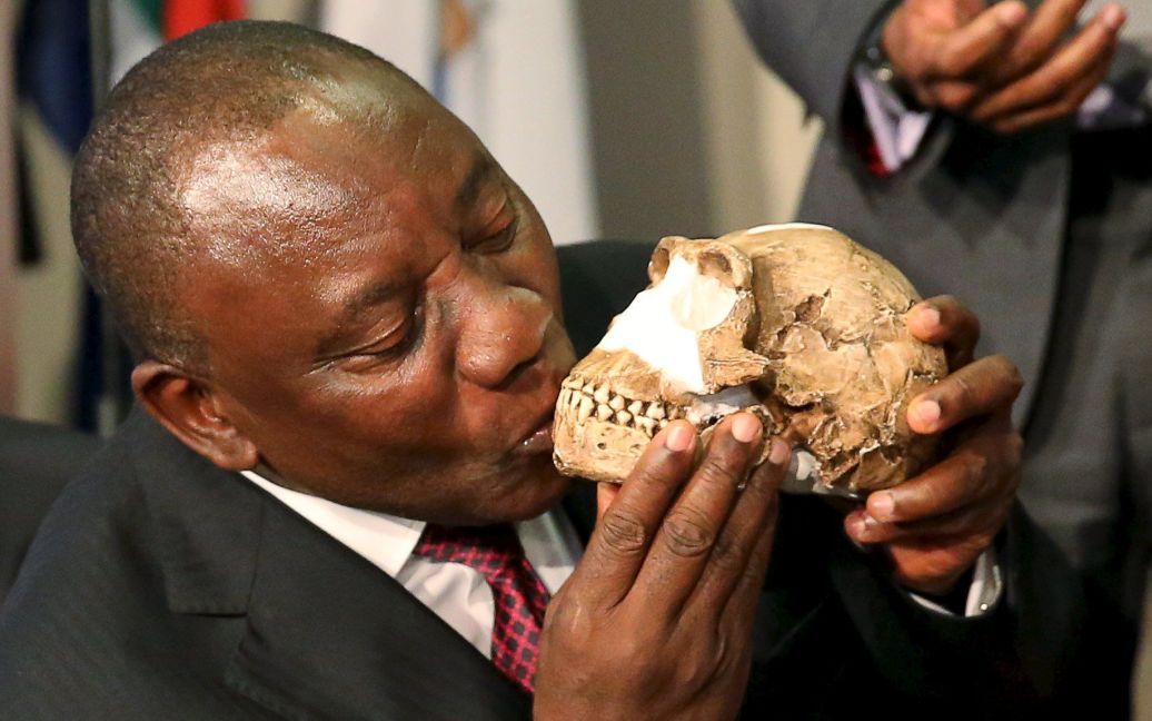 Вице-президент Южной Африки Кирилл Рамафоза целует череп недавно обнаруженного древнего вида человека "Homo Naledi". Окаменелости были обнаружены в глубокой пещере в 50 км к юго-западу от Йоханнесбурга. / © Reuters