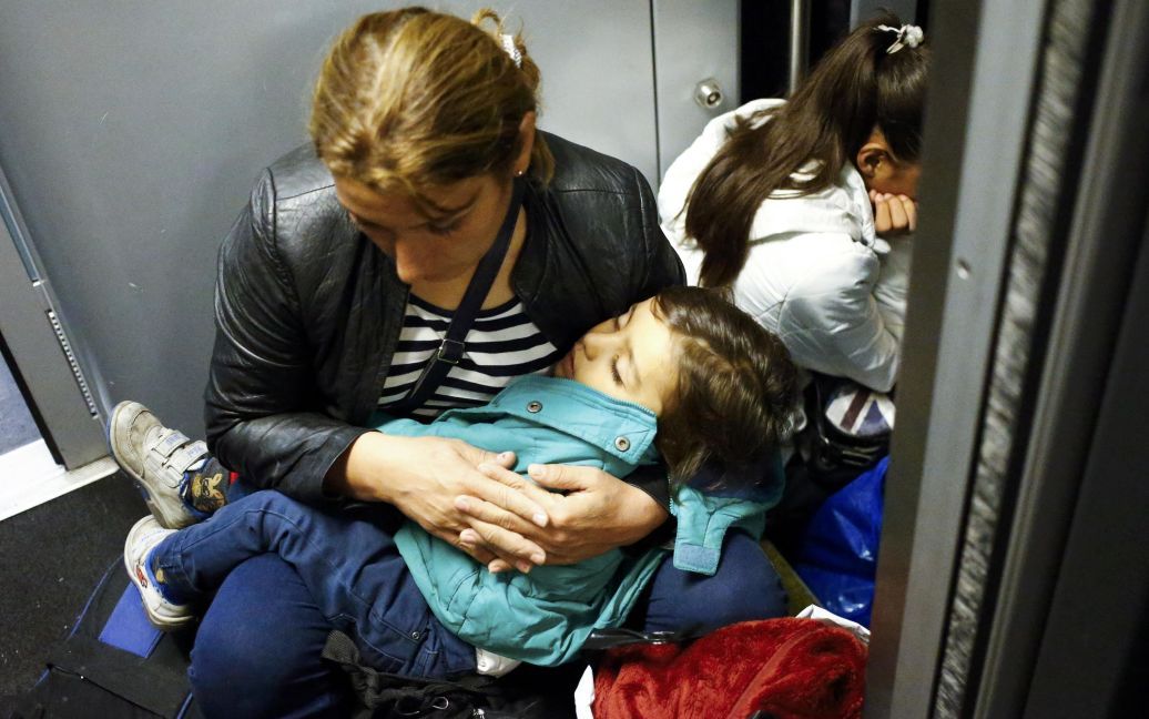 Беженка с ребенком сидит на полу на железнодорожном вокзале в городе Хедьешхалом в Венгрии, ожидая поездки в ЕС. Австрия и Германия 5 сентября открыли свои границы для тысяч изможденных мигрантов / © Reuters