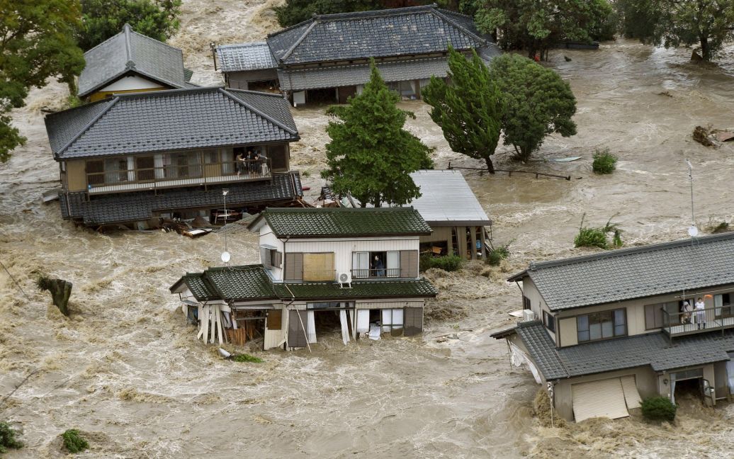 Жители затопленных домов в префектуре Ибараки в Японии ждут, когда к ним прилетят вертолеты спасателей. Более 90 000 японцев были вынуждены покинуть свои дома из-за масштабных наводнений и оползней, вызванных ударом сразу двух стихий - тайфуна Этау и шторма Кило. / © Reuters