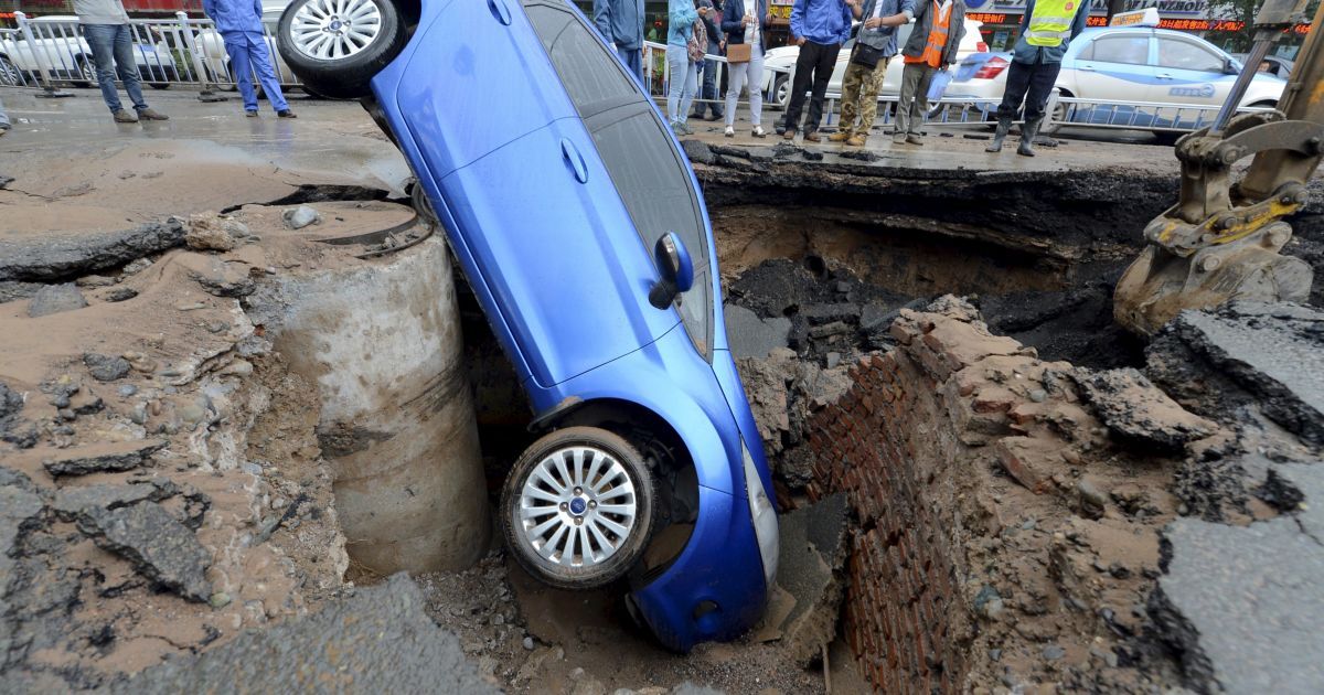 Автомобиль &laquo;попал&raquo; в водосточный колодец на улице в Ланьчжоу, что в китайской провинции Ганьсу. Водитель сумел выбраться невредимым / © Reuters
