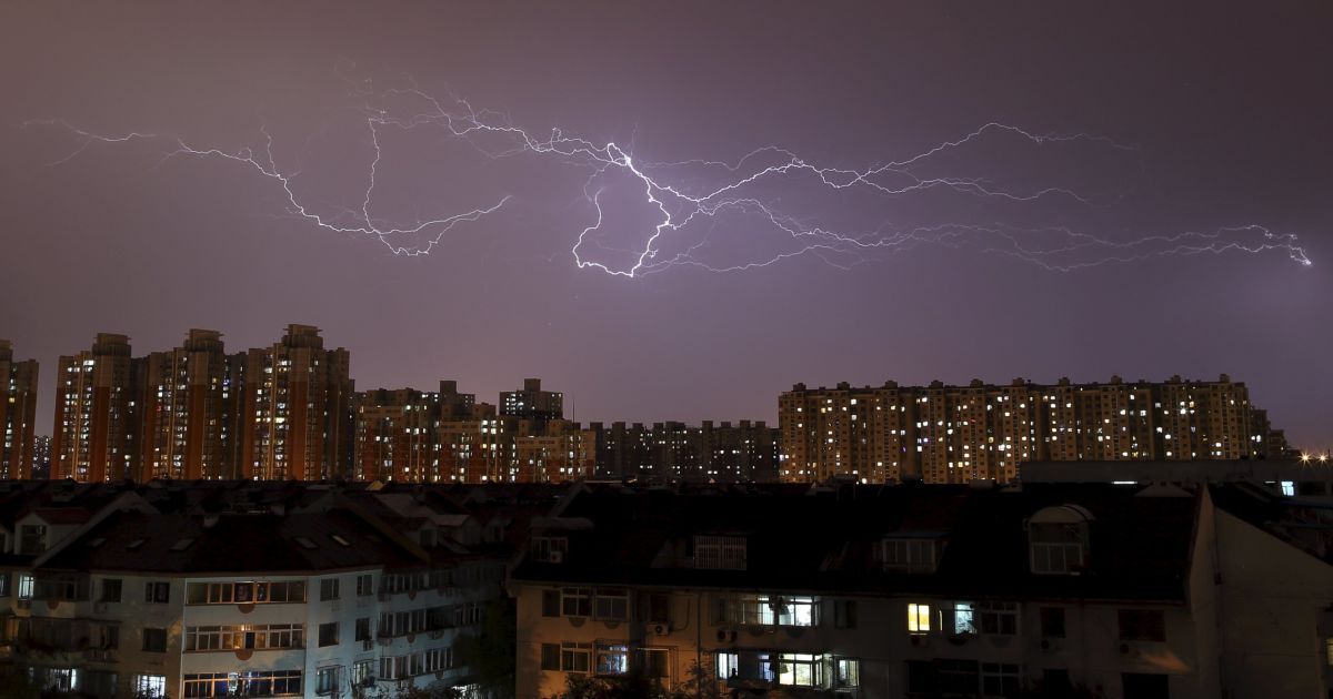 Молния ударяет в небе выше небоскребов во время грозы в Пекине, Китай. / © Reuters