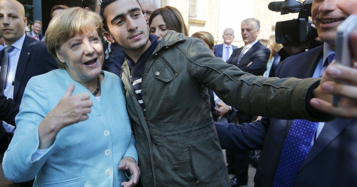 Мігрант робить селфі з канцлером Німеччини Ангелою Меркель за межами табору біженців недалеко від Федерального відомства з питань міграції та біженців після реєстрації на Шпандау Берліна, Німеччина. Загалом у ЄС зараз перебуває близько 160 тисяч біженців, але до найбагатших країн Європи намагаються потрапити ще сотні тисяч мігрантів. / © Reuters