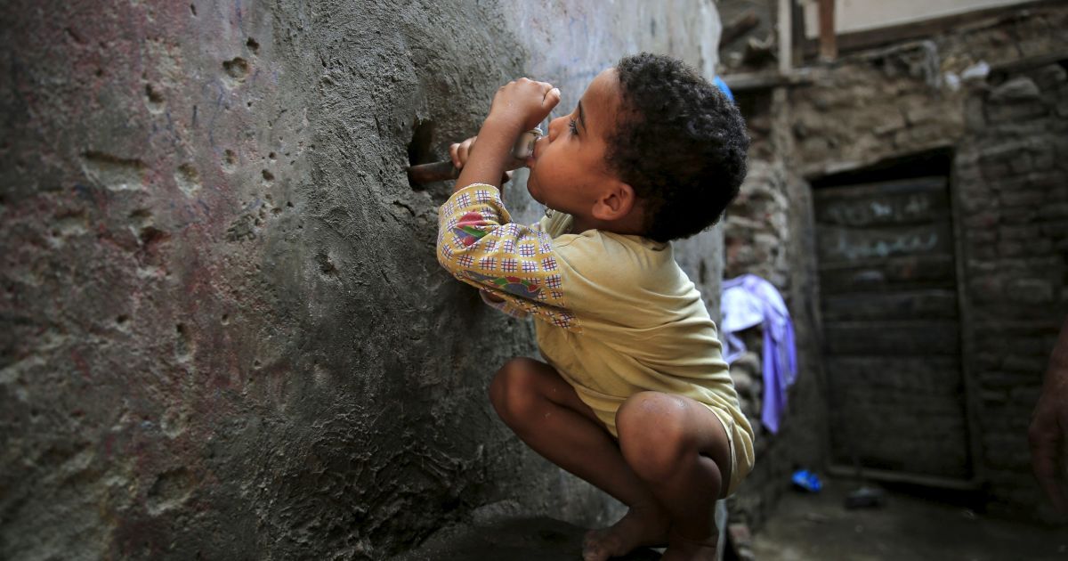 5-річний хлопчик п'є воду з крану біля його будинку в трущобах Ешаш-ель-Судан в районі Гізи, що на південь від столиці Єгипту Каїра. Наприкінці серпня між жителями місцевих нетрів та поліцією відбулися сутички після того, як були знищені близько 50 старих хатин. Влада намагається очистити район від нетрів, жителі яких в основному займаються утилізацією сміття та випічкою хліба. / © Reuters