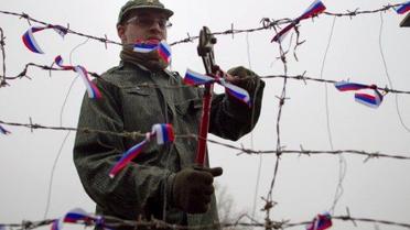 Словаччина, Братислава. Людина перерізає колючий дріт, символ залізної завіси, поруч із словацько-австрійським кордоном в Братиславі. Акцію провели на честь 22-ї річниці "оксамитової революції" 1989 року, мирного перевороту, який повалив комунізм у Чехословаччині. / © AFP